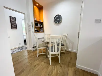 a dining room with a table and chairs and a clock at Exquisite 2BR Flat near Central Train Station in Glasgow
