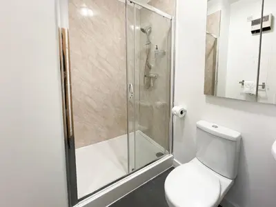 a bathroom with a toilet and a glass shower at Exquisite 2BR Flat near Central Train Station in Glasgow
