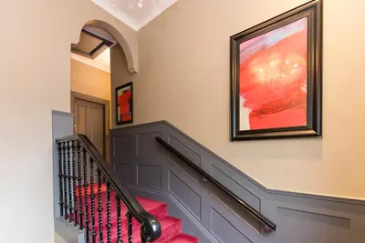 a staircase in a home with a painting on the wall at Irvine Guest House in Irvine
