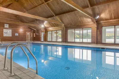 a swimming pool in a building with a wooden ceiling at The Kenmore Club in Kenmore