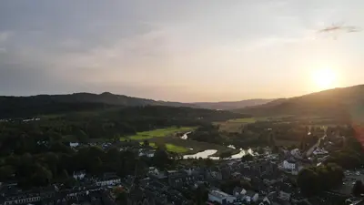 an aerial view of a city with the sun setting at The Knowe Guest House in Callander