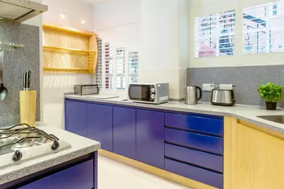 a kitchen with purple cabinets and a stove at Ramsay Gardens - Grand 4-Bedroom Apartment Next To Castle in Edinburgh