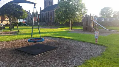 a little girl standing next to a playground equipment at Blair Drummond Holiday Home in Doune