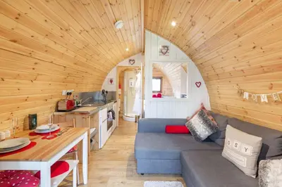 a living room with a blue couch in a tiny house at Loch Lomond Luxury Lodges in Drymen