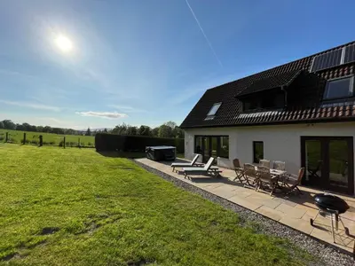 a patio with chairs and a grill and a house at Loch Lomond Luxury Lodges in Drymen