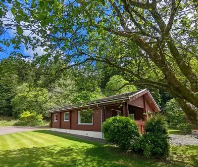 a small cabin in the middle of a yard at Ruskin Lodges Argyll, by Puck's Glen, Rashfield near Dunoon in Dunoon