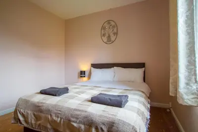 a bedroom with a bed with two blue pillows on it at Montgomery Apartments - Stevensons in Edinburgh
