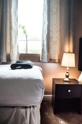 a bedroom with a bed and a lamp and a window at Montgomery Apartments - Stevensons in Edinburgh