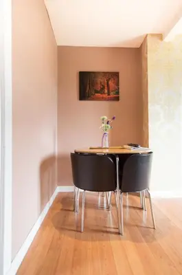 a dining room table with chairs and a vase of flowers at Montgomery Apartments - Stevensons in Edinburgh