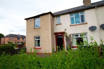 a brick house with a red door at Montgomery Apartments - Stevensons in Edinburgh