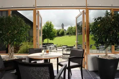a patio with a table and chairs and a large window at Stirling Court Hotel in Stirling