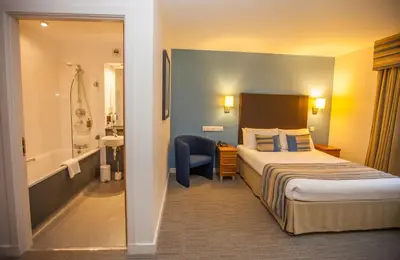 a hotel room with a bed and a bathroom at Stirling Court Hotel in Stirling