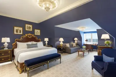 a bedroom with a king sized bed and blue walls at Trump Turnberry in Turnberry