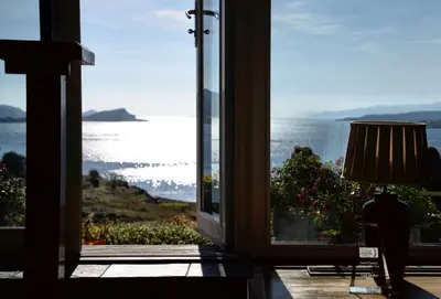 a room with a window looking out at the ocean at Loch Melfort Hotel in Ardfern