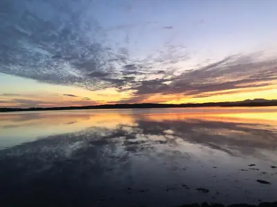 a reflection of the sky in the water at sunset at Loch Melfort Hotel in Ardfern
