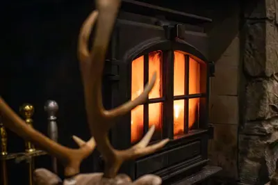 a candle in a fireplace with deer antlers at The Loans Inn in Troon