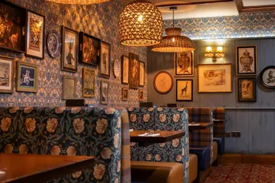 a restaurant with a bunch of pictures on the wall at The Loans Inn in Troon
