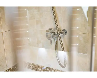 a shower with a shower head in a bathroom at The Crown in Callander