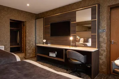a hotel room with a desk and a television at Carlton Hotel in Prestwick