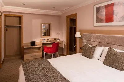 a hotel room with a bed and a desk at Carlton Hotel in Prestwick
