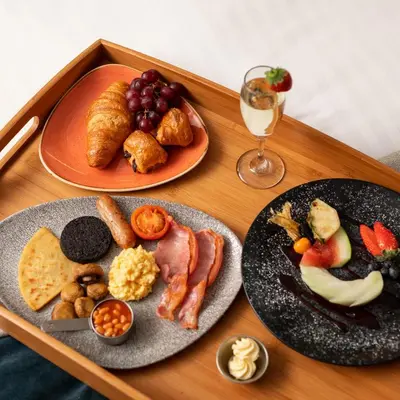 a table with two plates of food and a glass of wine at Carlton Hotel in Prestwick