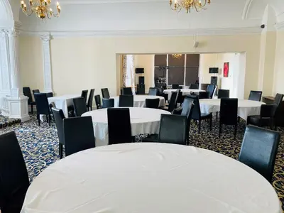 a room with white tables and chairs and chandeliers at Adamton Country House Hotel in Prestwick