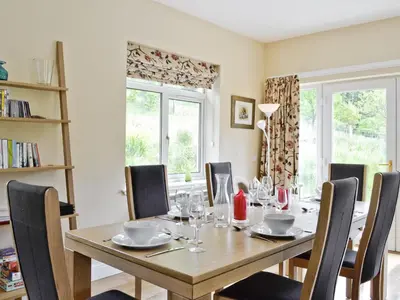 a dining room with a wooden table and chairs at Corrie Massan in Benmore