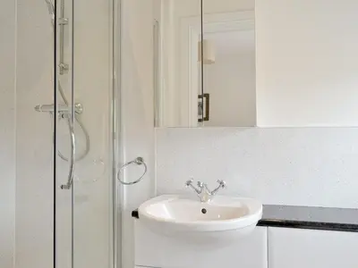 a white bathroom with a sink and a shower at Corrie Massan in Benmore