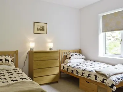 a bedroom with two beds and a window at Corrie Massan in Benmore