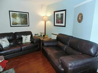 a living room with a leather couch and a table at Gracedieu in Killin