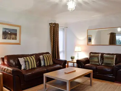 a living room with two leather couches and a table at Bruichladdich in Rothesay