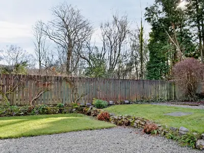 a backyard with a wooden fence and a garden at Baravullin in Benderloch