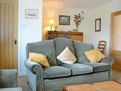 a living room with a blue couch with yellow pillows at Baravullin in Benderloch