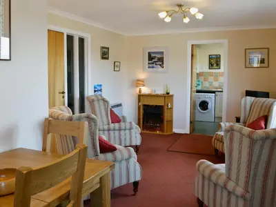 a living room with chairs and a table at Ferry View in Oban