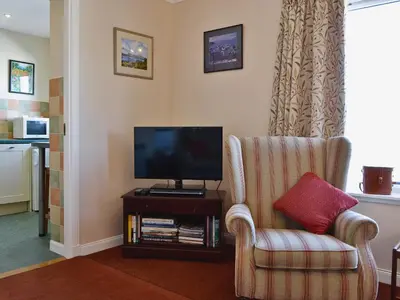 a living room with a chair and a television at Ferry View in Oban