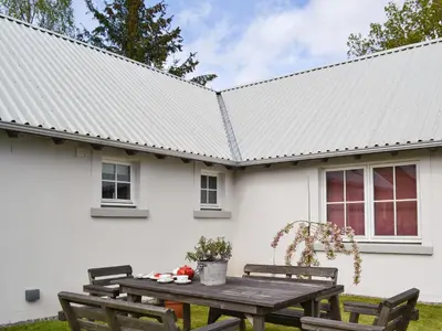 a white house with a picnic table in front of it at Ben Hennie in Mill of Fortune
