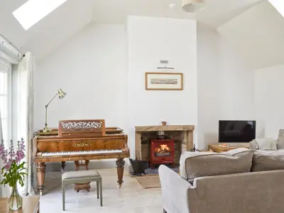 a living room with a piano and a fireplace at Ben Hennie in Mill of Fortune