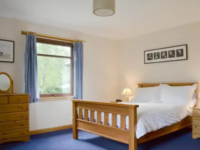 a bedroom with a bed and a window at Bethany Cottage in Aberfoyle