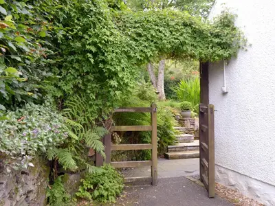 an entrance to a garden with a wooden gate at Old Stones in Glendevon