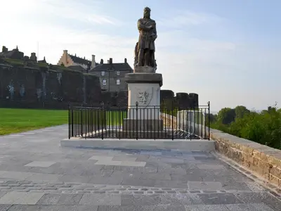 a statue of a woman on a pedestal in front of a castle at Ross Cottage in Cairneyhill