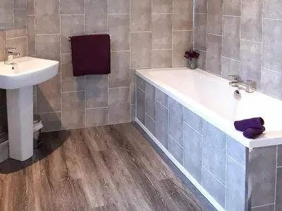 a bathroom with a bath tub and a sink at Old Barn Farmhouse - Cc in Uplawmoor