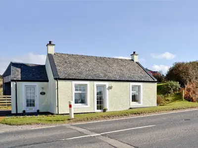 a small white house on the side of the road at Belloch Cottage in Glenbarr