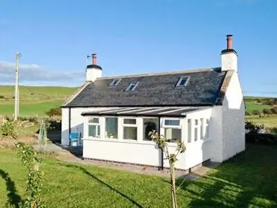 a small white house in the middle of a field at Wee Dug Hoose in Glenluce