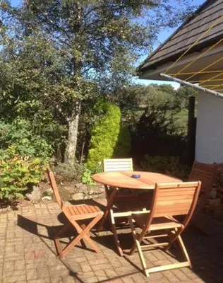 a wooden table and two chairs on a patio at Bramble Cottage 1, 2 & 3 in Lochdon