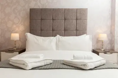 a bedroom with a bed with towels on it at Dunfermline - Premium Two Bedroom Apartment - KW in Dunfermline