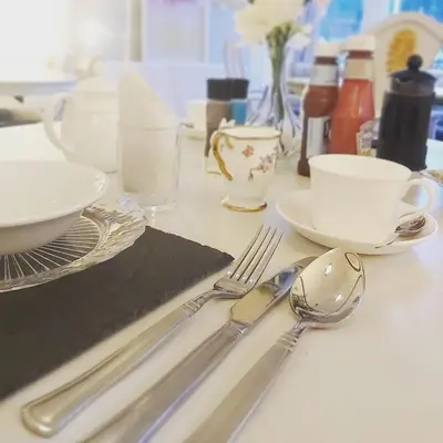 a table with silver utensils on a table at The Ben Sheann in Strathyre