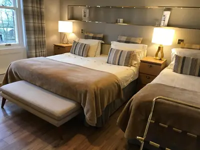 a bedroom with two beds and two lamps on tables at Sandhill House in Troon