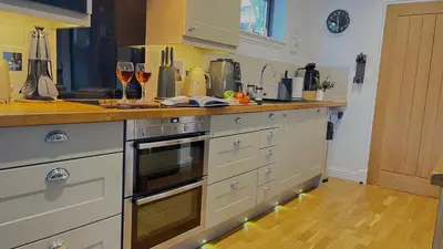 a kitchen with a counter with glasses of wine at Bluebell Cottage with Hot Tub in Ballachulish