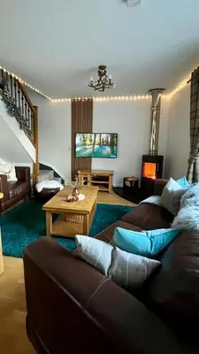 a living room with a couch and a table at Bluebell Cottage with Hot Tub in Ballachulish