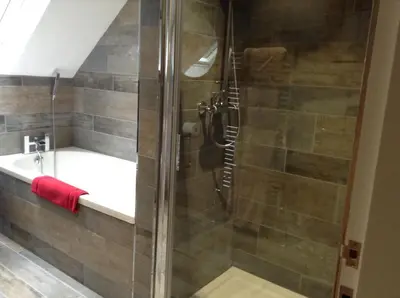 a bathroom with a shower and a tub and a sink at The BurnHowf apartment in Balloch